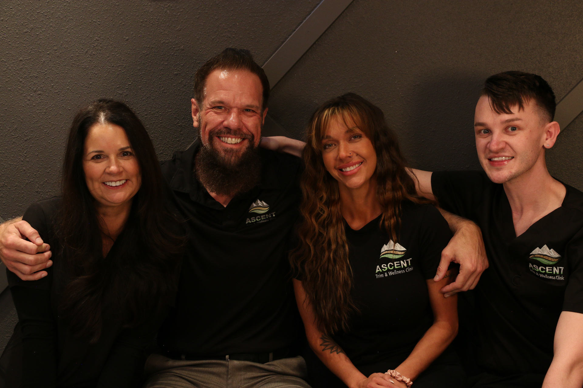 The Ascent Trim & Wellness team together beneath the clinic logo in Colorado Springs